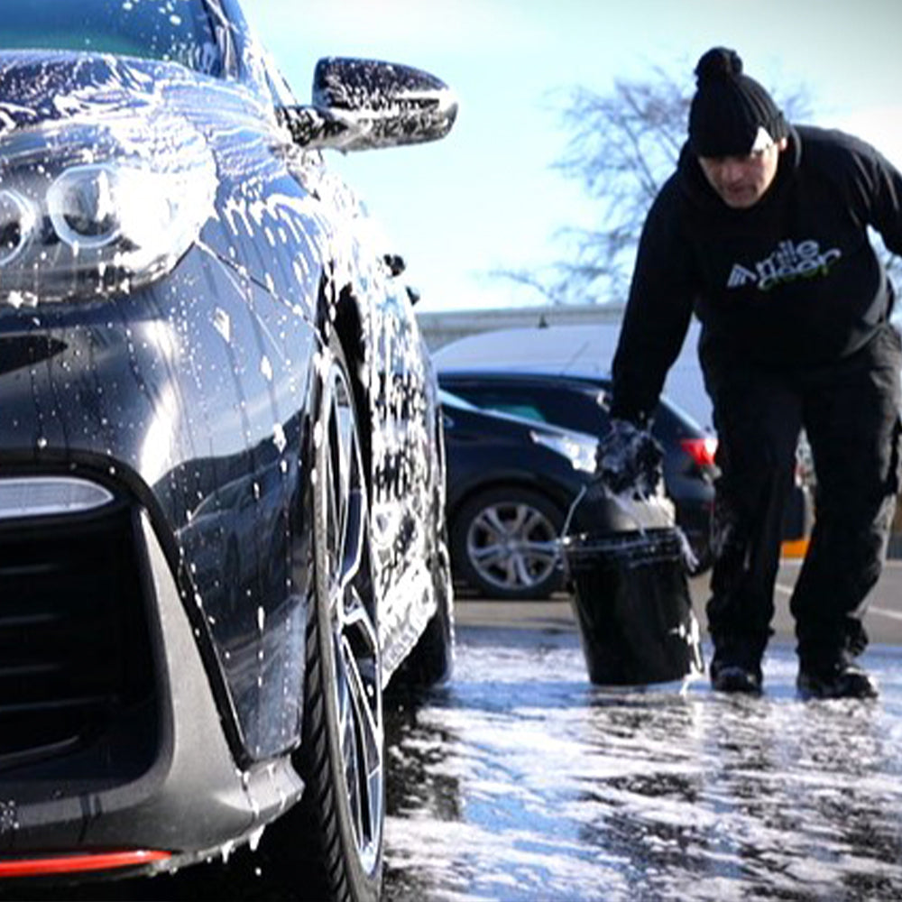 fill heavy-duty detailing bucket at side of car being washed